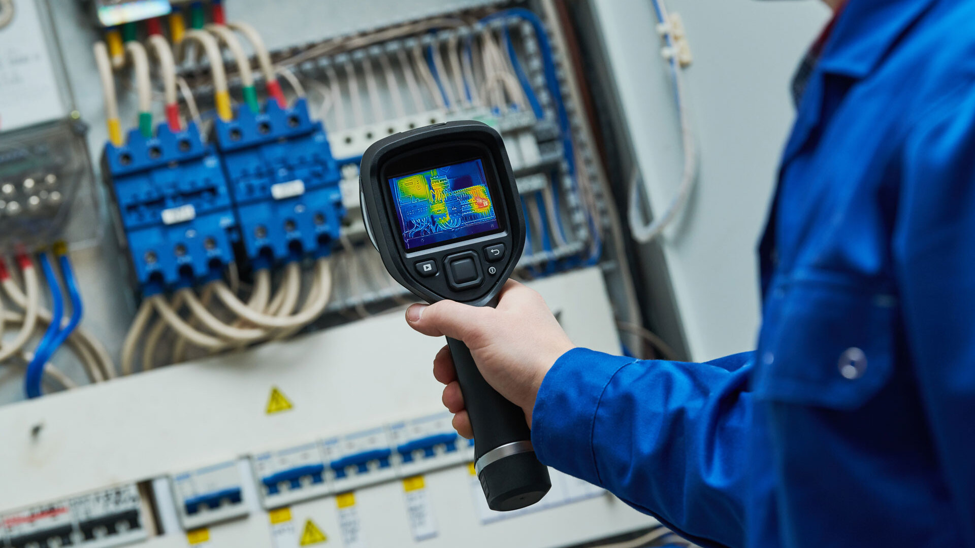 Leistung-Pruefung 3 Techniker prüft via Thermografie eine Schaltanlage